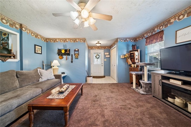 living area with tile patterned floors, a textured ceiling, ceiling fan, and carpet