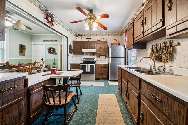 kitchen with light countertops, stainless steel appliances, a ceiling fan, and a sink