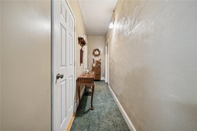 hall featuring baseboards and carpet
