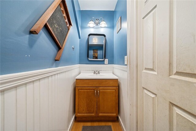 bathroom featuring vanity, wainscoting, and wood finished floors