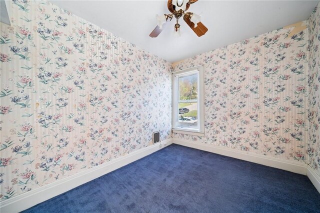 unfurnished room featuring wallpapered walls, visible vents, and dark colored carpet