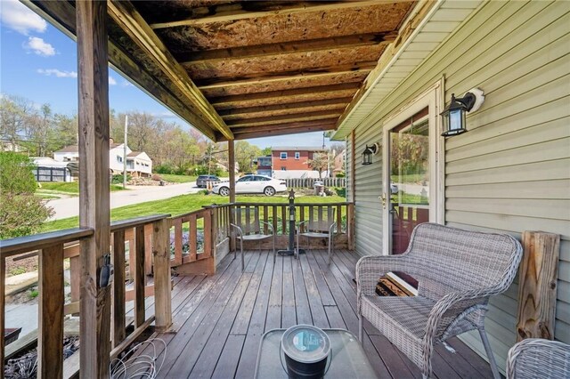 wooden terrace with covered porch and a residential view