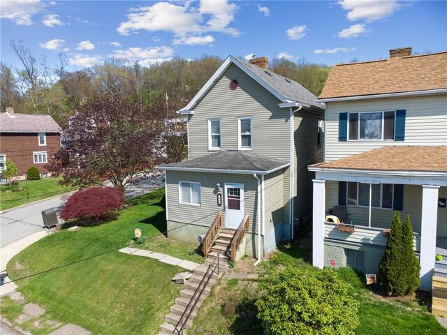 view of front of property with entry steps and a front lawn