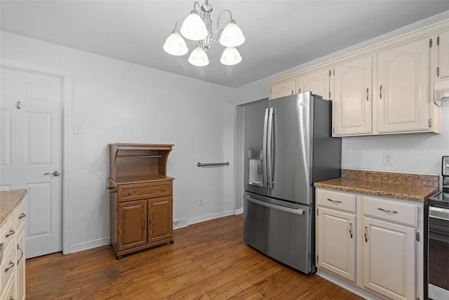kitchen featuring baseboards, dark wood-style floors, a chandelier, and stainless steel appliances