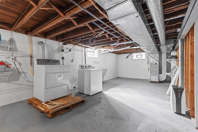 basement with heating unit and washer and clothes dryer