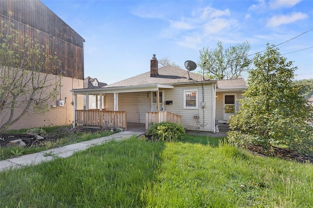rear view of house featuring covered porch and a chimney