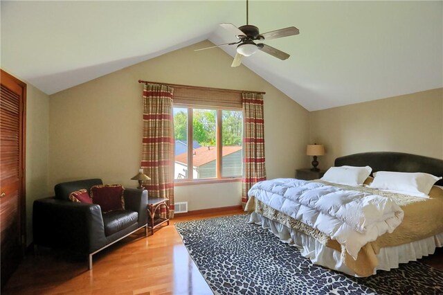bedroom with ceiling fan, visible vents, vaulted ceiling, wood finished floors, and a closet