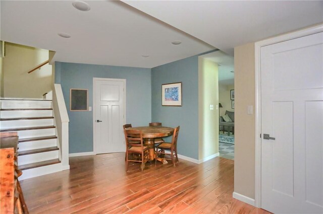 dining room with stairway, baseboards, and light wood finished floors