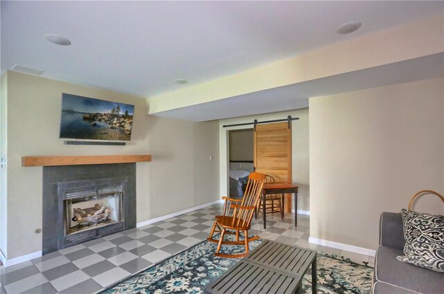 living area featuring tile patterned floors, baseboards, a fireplace, and a barn door