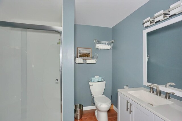 full bathroom with toilet, baseboards, a shower stall, and vanity