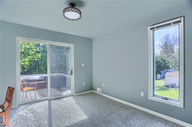 empty room with carpet flooring, baseboards, and visible vents
