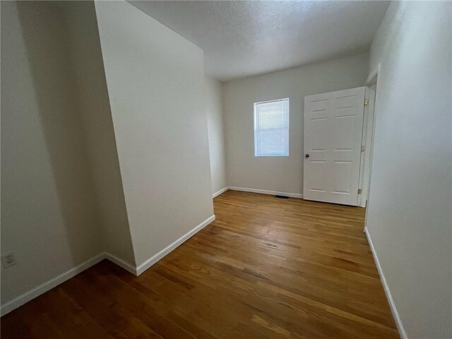 empty room featuring baseboards and wood finished floors