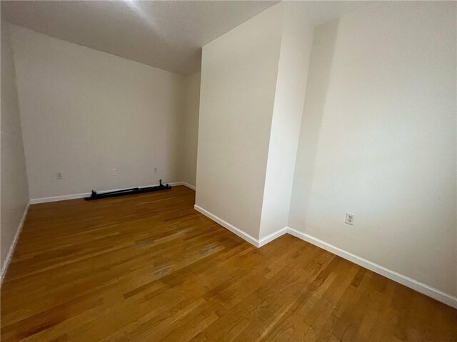 empty room featuring baseboards and wood finished floors