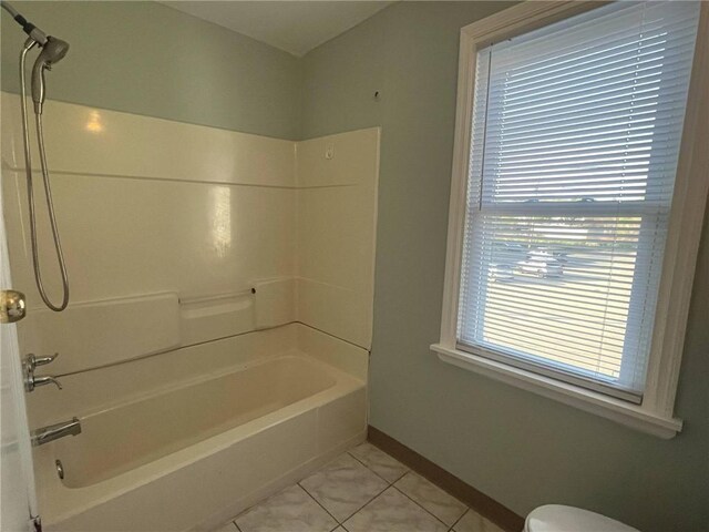 bathroom with shower / bathtub combination, baseboards, toilet, and tile patterned flooring