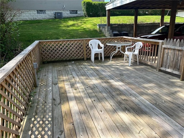 wooden deck with central air condition unit and a yard