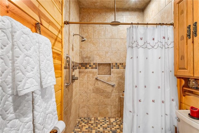 bathroom featuring toilet and a stall shower