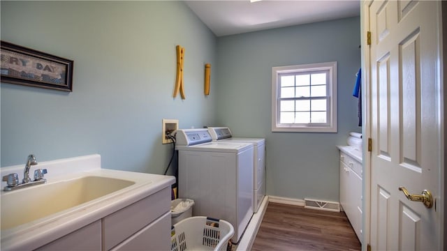107 Skyview Dr, Buffalo Twp But, PA 16055 - laundry room with washing machine and clothes dryer, cabinet space, a sink, baseboards, and dark wood-type flooring
