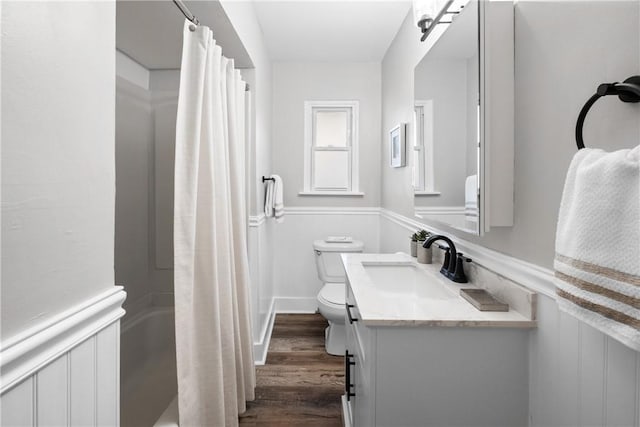 bathroom featuring vanity, shower / bath combo, toilet, and wood finished floors