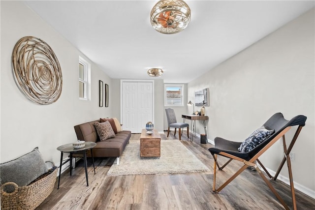 living area with baseboards and wood finished floors