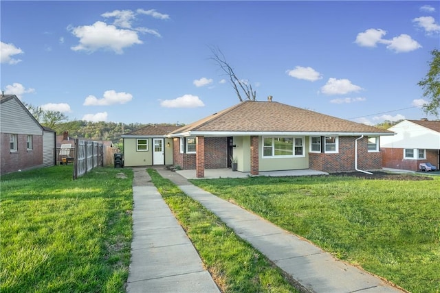 view of front of property with brick siding, a front lawn, and fence