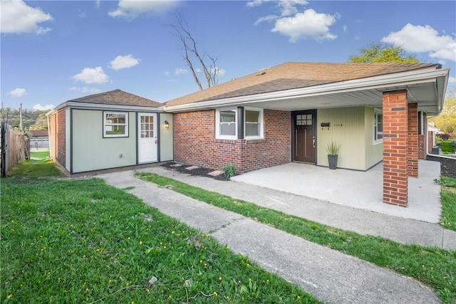 view of front of property with a porch, brick siding, fence, and a front yard