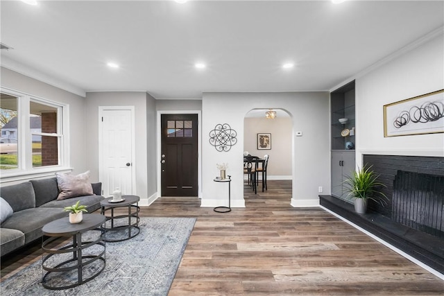 living area with recessed lighting, arched walkways, and baseboards