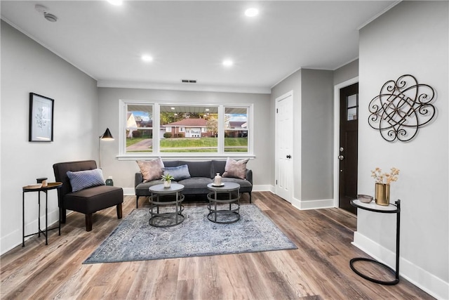 sitting room with crown molding, recessed lighting, baseboards, wood finished floors, and visible vents