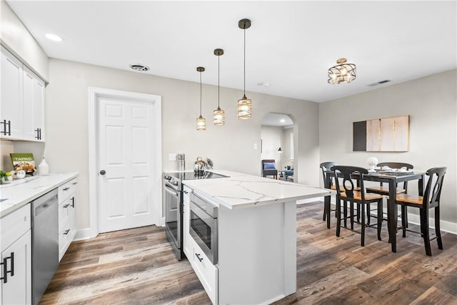 kitchen featuring visible vents, appliances with stainless steel finishes, arched walkways, a peninsula, and white cabinetry