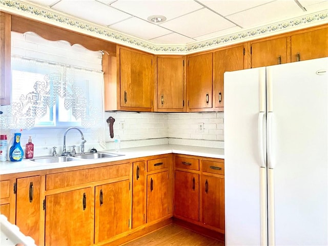 kitchen featuring freestanding refrigerator, a sink, and light countertops