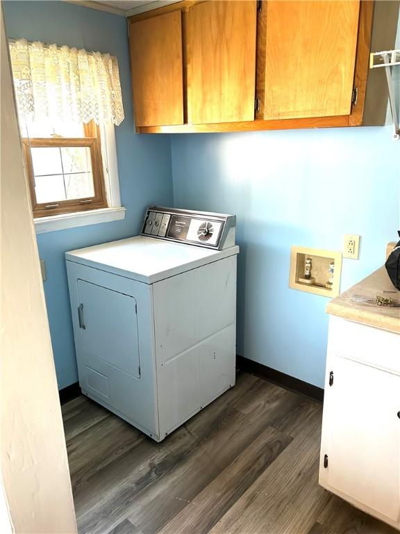 laundry area featuring baseboards, washer / dryer, cabinet space, and dark wood finished floors