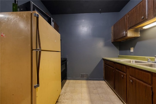 616 Evans Ave, Mckeesport, PA 15132 - kitchen with freestanding refrigerator, electric range, a sink, light countertops, and light floors