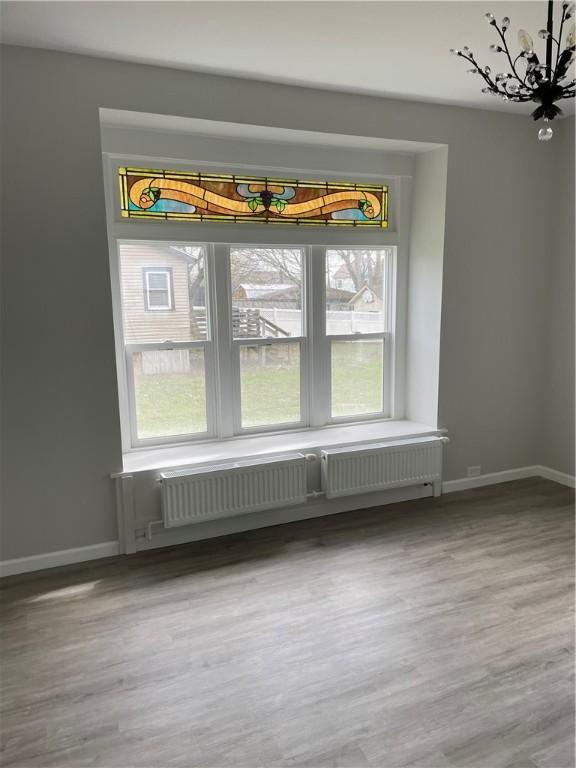 280 Spruce, Sharon, PA 16146 - unfurnished dining area featuring a healthy amount of sunlight, baseboards, wood finished floors, and a notable chandelier