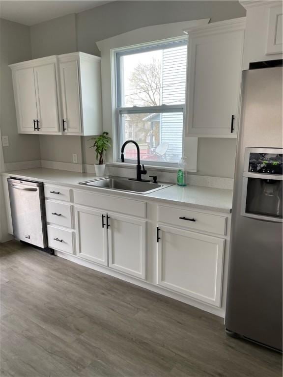280 Spruce, Sharon, PA 16146 - kitchen with white cabinets, appliances with stainless steel finishes, a sink, light countertops, and wood finished floors