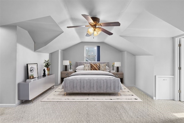 carpeted bedroom with ceiling fan, vaulted ceiling, and baseboards