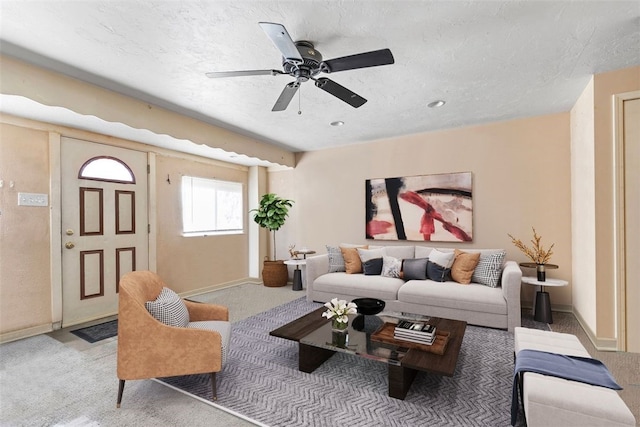 living area featuring carpet flooring, a ceiling fan, and baseboards