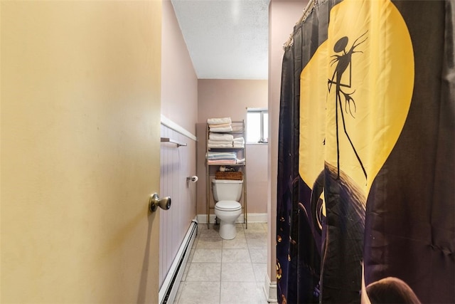 bathroom featuring toilet, a baseboard heating unit, and tile patterned flooring