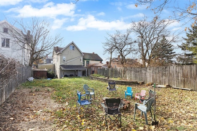 view of yard featuring a fenced backyard and a fire pit
