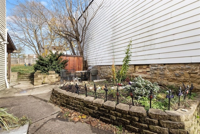 view of side of home with a patio area and fence