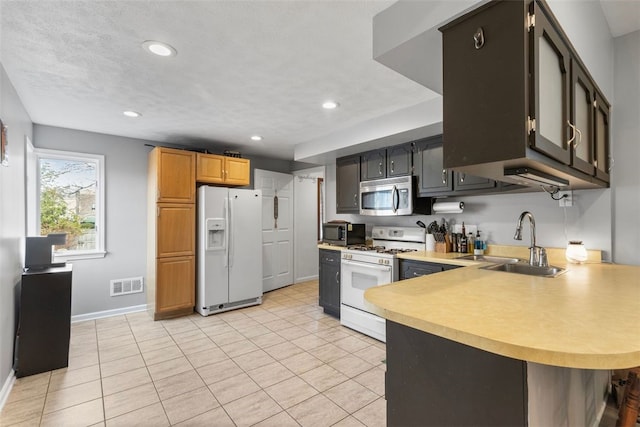 kitchen featuring visible vents, light tile patterned flooring, white appliances, light countertops, and a sink