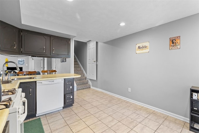 kitchen featuring light tile patterned flooring, a sink, white appliances, recessed lighting, and baseboards