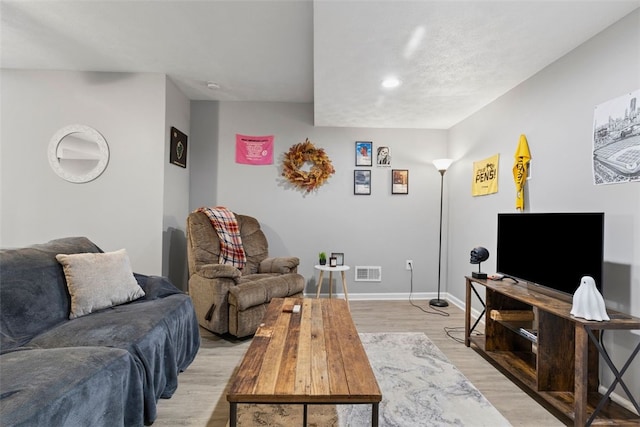 living area with recessed lighting, baseboards, light wood finished floors, and visible vents