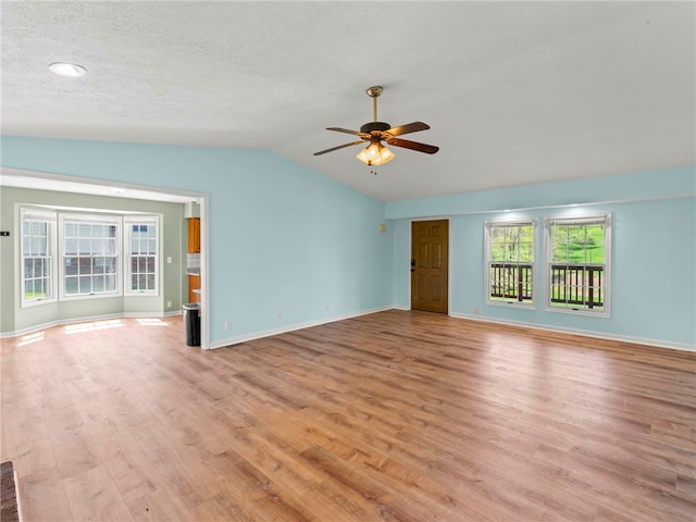 297 Rainey Rd, Somerset Twp, PA 15330 - unfurnished living room with a ceiling fan, baseboards, light wood finished floors, and lofted ceiling