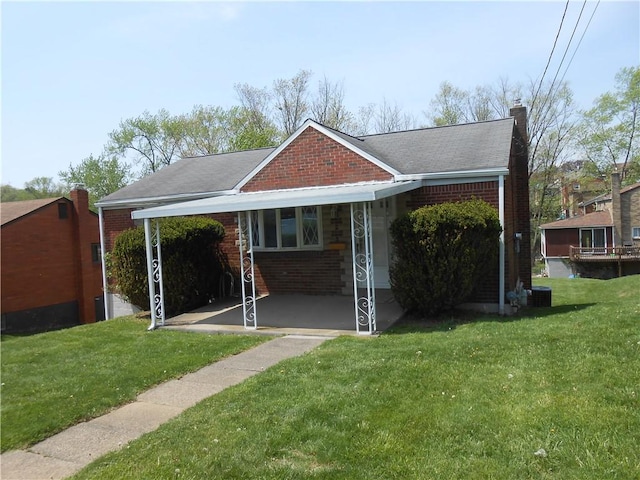 view of front of house featuring brick siding, a chimney, and a front lawn