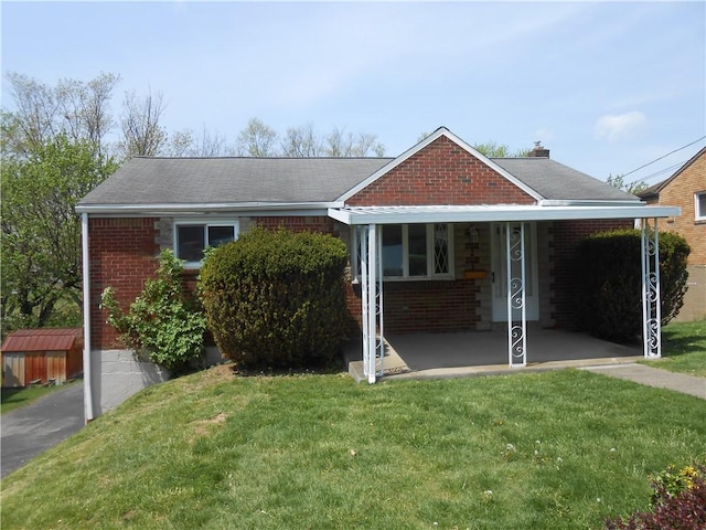 view of front facade with brick siding and a front lawn