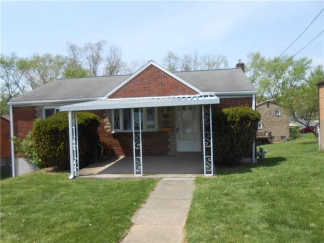 bungalow with brick siding, a front lawn, and a chimney