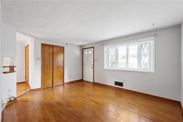 interior space with visible vents, wood-type flooring, and baseboards
