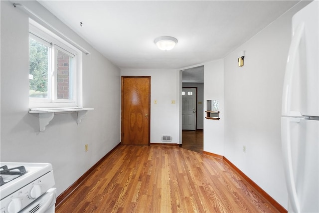 unfurnished dining area featuring visible vents, light wood-style flooring, and baseboards