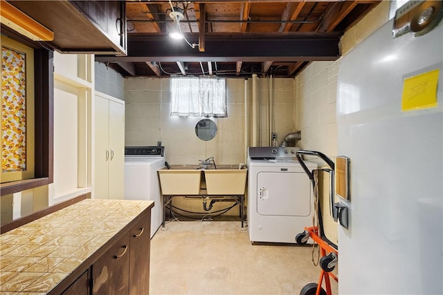 laundry area featuring a sink, heating unit, cabinet space, and independent washer and dryer