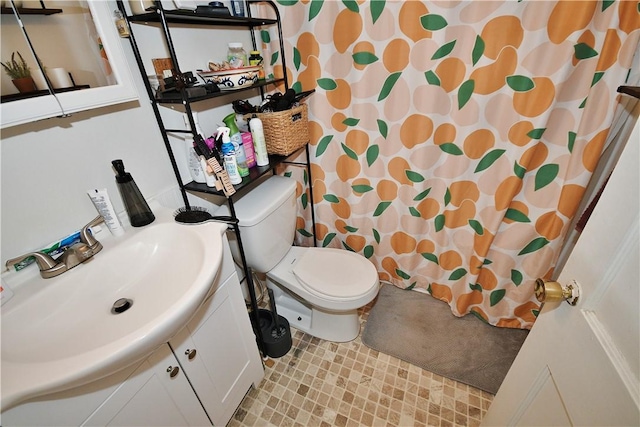 bathroom featuring vanity, toilet, and curtained shower
