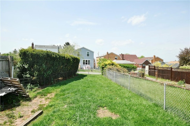 view of yard with a fenced backyard and a residential view